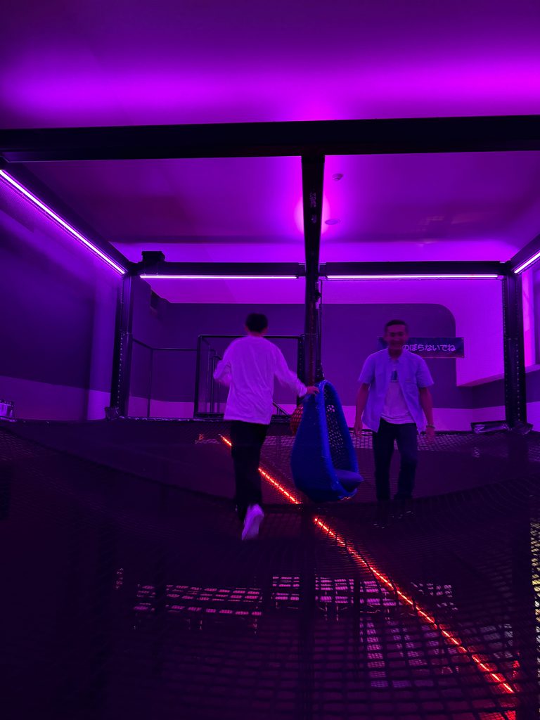 Purple-lit corridor with laser beams at the entrance to a Huis Ten Bosch attraction