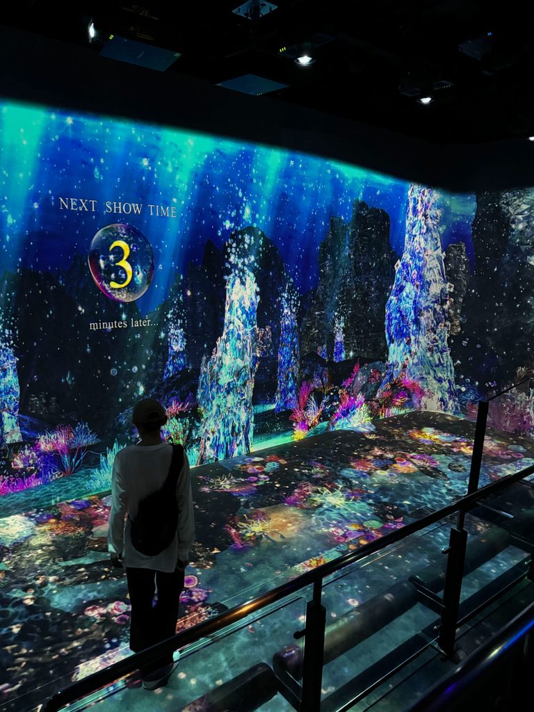 Standing before a glowing digital art wall as the next show counts down at Huis Ten Bosch