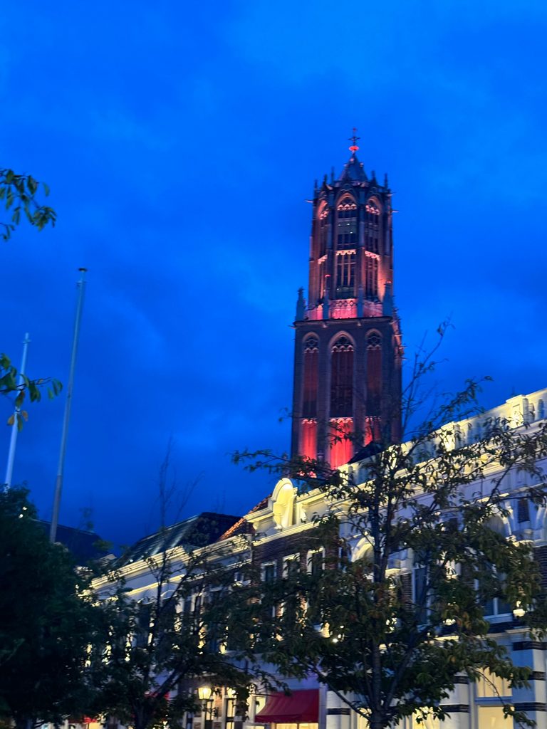 The Domtoren tower lit up red against the deep blue evening sky at Huis Ten Bosch