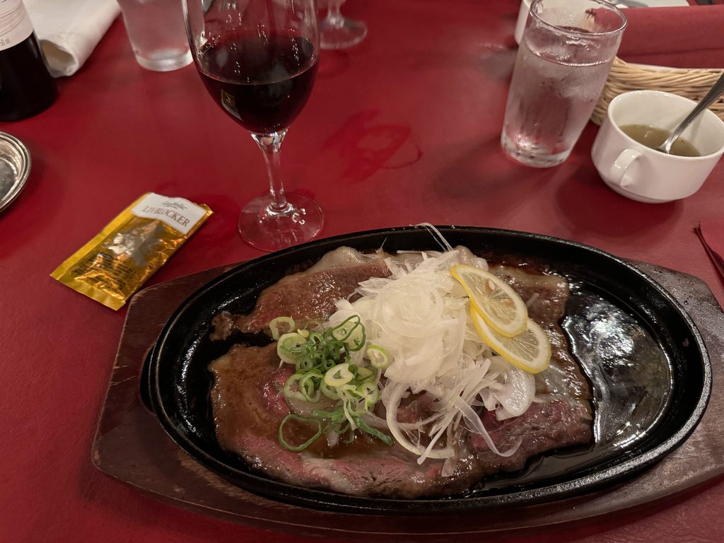 Sasebo lemon steak sizzling on a hot iron plate with shredded onion and a slice of lemon