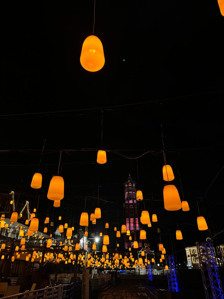 Orange lanterns glowing overhead at the night illumination in Huis Ten Bosch