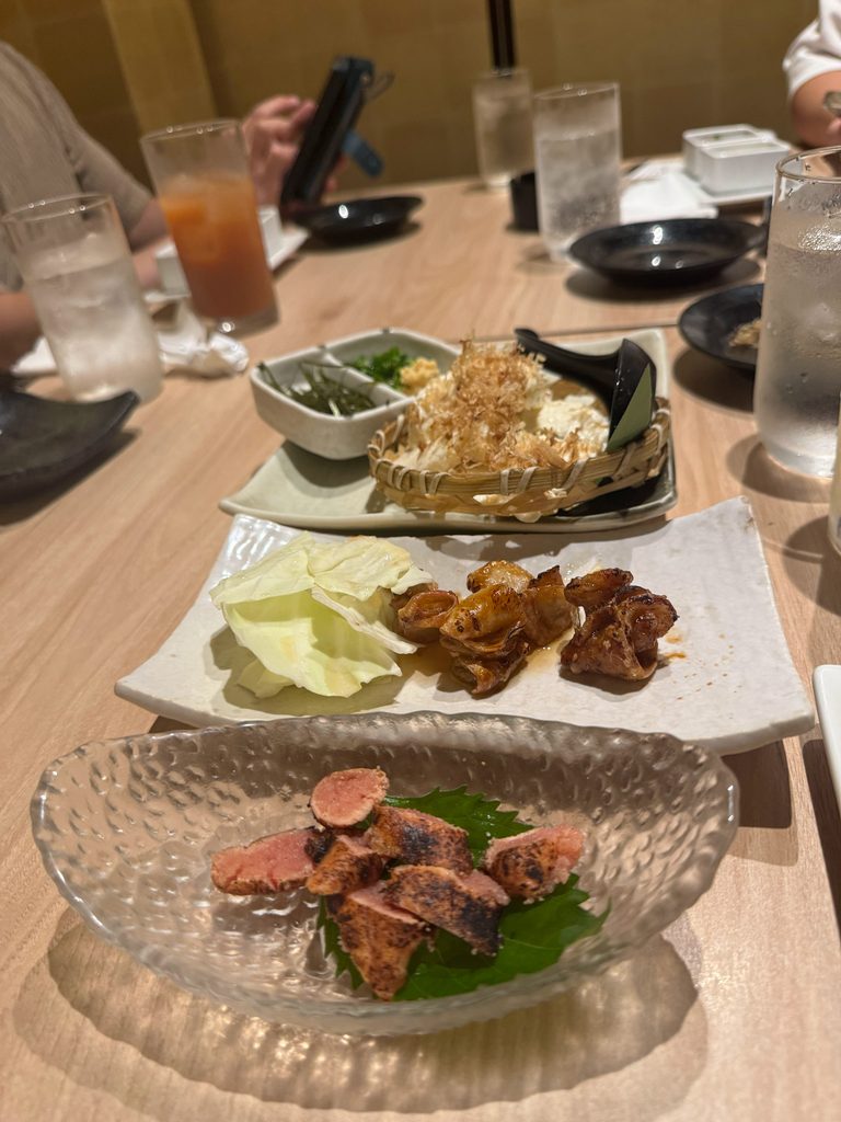 An izakaya spread of potato salad, grilled dishes and sashimi in Fukuoka