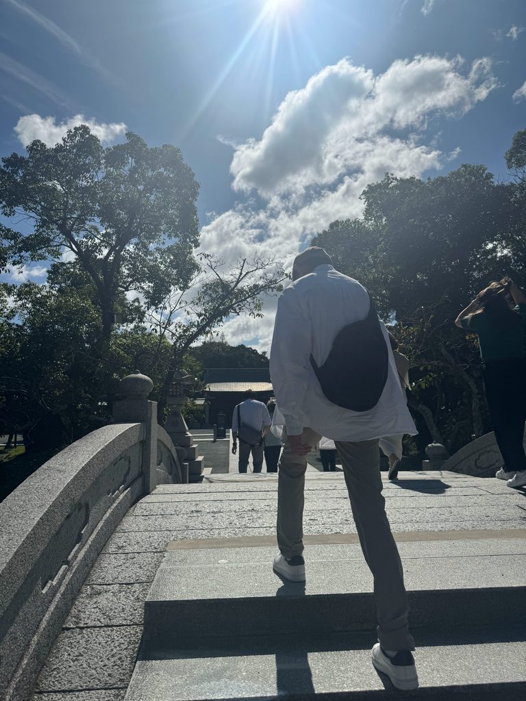 Climbing the sunlit stone steps into the grounds of Munakata Taisha