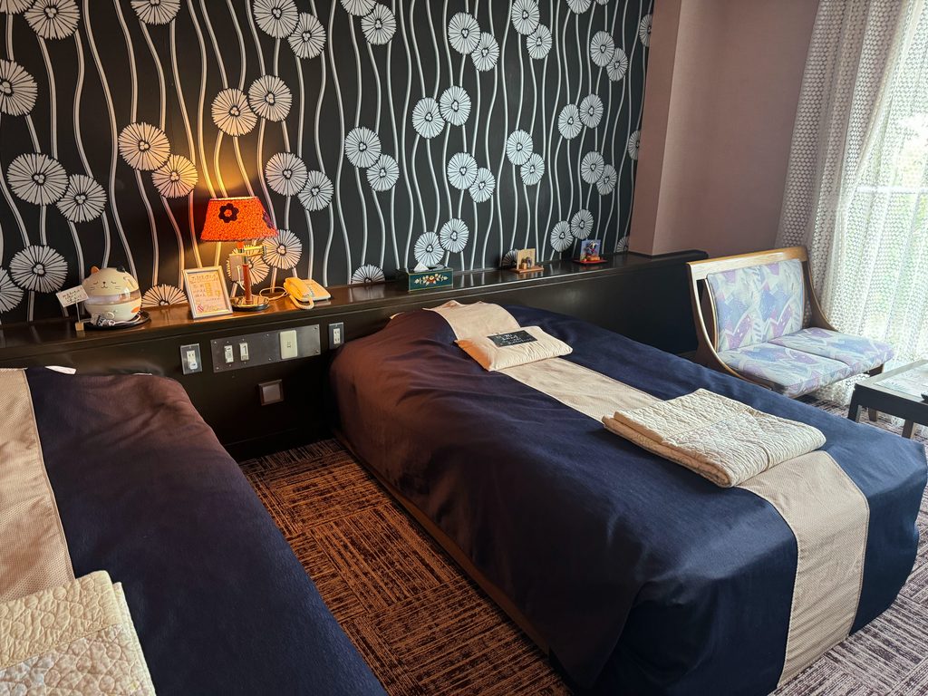 Our guest room at Kahori no Sato Hanamura with two beds and patterned wallpaper