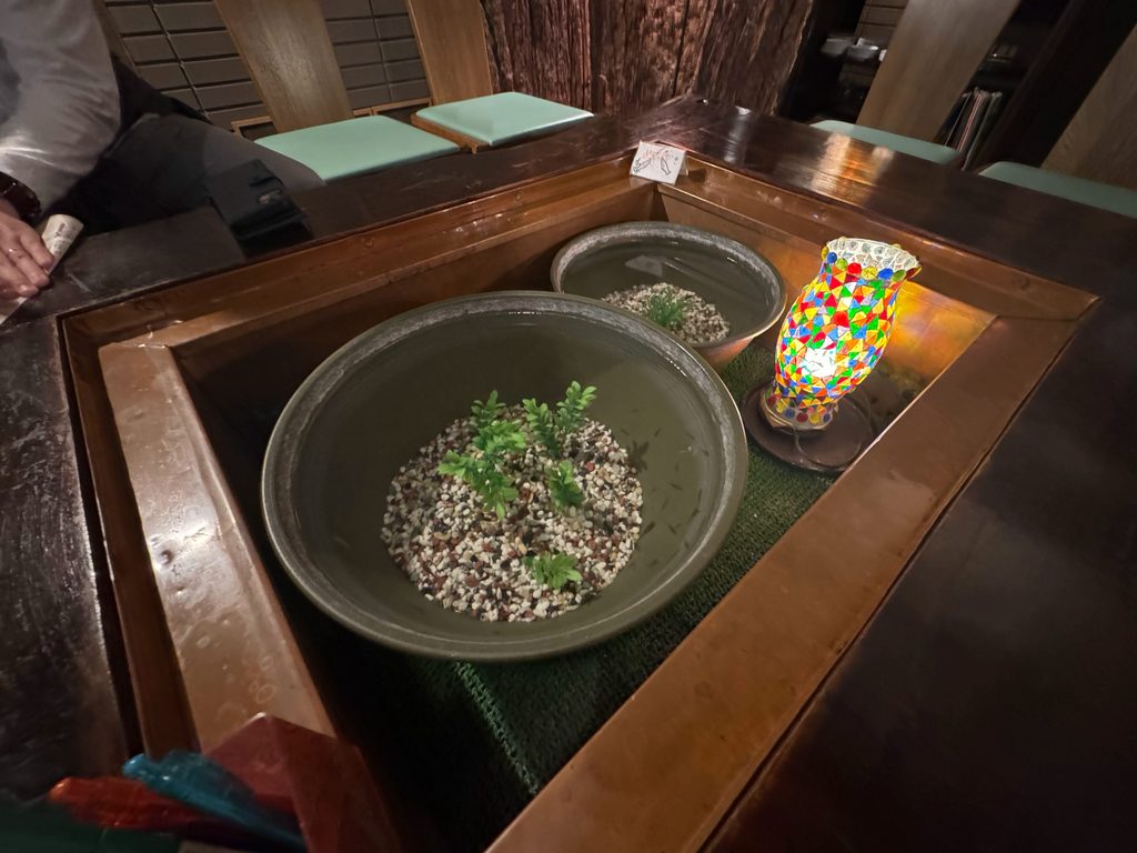 A sunken hearth-style table with large ceramic bowls in the ryokan lounge