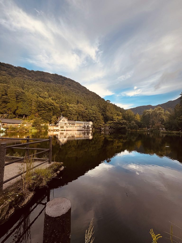 Lake Kinrin in Yufuin reflecting the clouds and the forested hills in the late afternoon