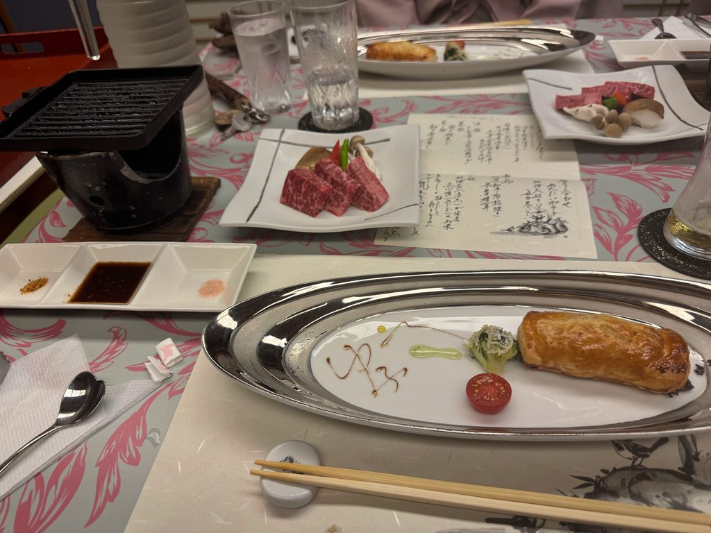 Marbled wagyu beef ready for the tabletop grill and a baked fish dish at the ryokan dinner