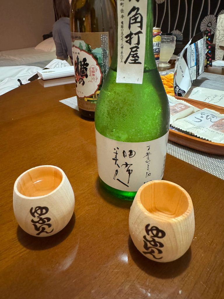 A bottle of local sake with two wooden cups in our room at the ryokan