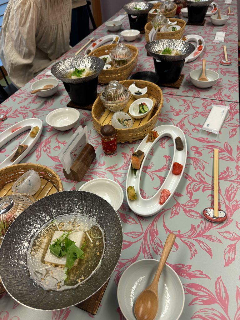 A breakfast table full of small dishes, tofu and hot pots at Kahori no Sato Hanamura